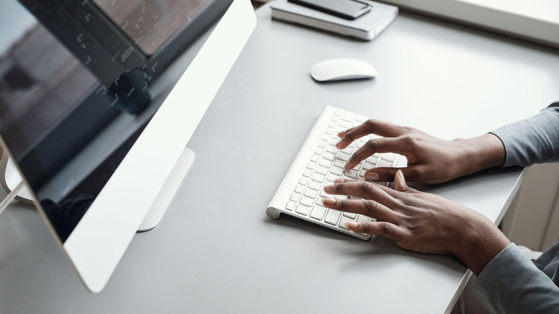 Collaboratore che scrive al computer in ufficio, a un passo dall’inserire dati in un assistente di intelligenza artificiale